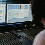 Künstliche Intelligenz in der Musikproduktion: Sound auf Knopfdruck Die Musikproduktion war lange ein Handwerk, das viel Technikverständnis, teure Ausrüstung und vor allem Zeit verlangte. Heute reicht oft ein Laptop, ein Kopfhörer – und zunehmend auch ein KI-Tool, das aus wenigen Vorgaben Beats, Harmonien oder sogar grobe Arrangements ableitet. „Sound auf Knopfdruck“ ist dabei weniger Magie als ein Ergebnis von Machine Learning, Audioanalyse und generativen Modellen, die Muster aus riesigen Datenmengen gelernt haben. Trotzdem ist es ein Fehler, KI als reine Abkürzung zu betrachten. Sie kann den Einstieg erleichtern und Routinearbeiten beschleunigen, aber sie nimmt Ihnen nicht automatisch die kreative Entscheidung ab. Wer die Vorschläge ungefiltert übernimmt, landet schnell bei Ergebnissen, die technisch sauber, aber künstlerisch austauschbar wirken. Wer KI als Werkzeug nutzt, das Optionen liefert, kann dagegen schneller experimentieren und bewusster kuratieren. Was KI heute in der Produktion tatsächlich leistet KI in der Musikproduktion ist kein einzelnes Feature, sondern eine ganze Palette an Anwendungen. Einige Systeme generieren musikalisches Material wie Melodien, Akkordfolgen oder Drum-Patterns. Andere unterstützen beim Sounddesign, etwa indem sie aus einem Preset viele Varianten erstellen oder Klangfarben an eine Referenz annähern. Ein dritter Bereich ist die technische Assistenz: Tools erkennen Timing-Probleme, reduzieren Rauschen, helfen beim De-Esser, schlagen EQ-Korrekturen vor oder erstellen einen ersten Mastering-Entwurf. Wichtig ist die Unterscheidung zwischen „generativ“ und „assistierend“. Generative KI erstellt neues Material auf Basis von Eingaben (Prompts, Genre-Hinweisen, Referenzen). Assistierende KI analysiert vorhandenes Audio und optimiert es. Beides kann beeindruckend wirken – aber es bleibt eine Vorstufe: Der entscheidende Schritt ist die künstlerische Auswahl und die Frage, warum ein Track genau so klingen soll. Songwriting und Arrangement: Mehr Ideen, weniger Blockade Viele Produzierende kennen den Moment, in dem eine Idee da ist, aber die Umsetzung stockt: Die Hook sitzt, doch die Strophe trägt nicht; der Beat funktioniert, aber der Drop wirkt flach. KI kann hier wie ein Ideen-Generator arbeiten. Sie liefert alternative Akkordwege, Variationen eines Motives oder rhythmische Abwandlungen, die man selbst vielleicht nicht sofort ausprobiert hätte. Das ist vor allem am Anfang einer Produktion nützlich, wenn es darum geht, schnell unterschiedliche Richtungen zu testen. Gleichzeitig entsteht eine neue Verantwortung: Wenn KI zehn mögliche Hooks anbietet, muss man umso klarer wissen, welche Stimmung, Energie und Dramaturgie man eigentlich sucht. KI erhöht die Menge an Möglichkeiten – Ihre Aufgabe ist es, daraus einen Track mit Aussage zu formen. Sounddesign und Vocals: Schneller zum „Signature Sound“, aber nicht ohne Regeln Im Sounddesign ist KI besonders stark, weil Audio mathematisch gut beschreibbar ist: Spektren, Transienten und Dynamik liefern eindeutige Signale. Moderne Tools können aus einem simplen Preset zahlreiche Varianten erzeugen oder aus einer Referenzaufnahme ein „ähnliches“ Klangprofil ableiten. Das beschleunigt den Weg zum passenden Bass, Pad oder Lead-Sound und macht Experimentieren günstiger, weil man weniger Zeit in Trial-and-Error investiert. Bei Vocals wird es sensibler. KI kann Timing glätten, Tonhöhen stabilisieren, Atemgeräusche reduzieren oder Harmonien generieren. Gleichzeitig ist Voice-Cloning technisch möglich, was rechtliche und ethische Fragen aufwirft: Wem gehört eine Stimme, und was ist erlaubt? Für Veröffentlichungen gilt: Einwilligungen, Rechteklärung und Transparenz sind essenziell. Selbst im Hobbybereich lohnt sich Vorsicht, weil man schnell in Grauzonen rutscht, die man später nicht mehr sauber auflösen kann. Mixing und Mastering: „Klingt fertig“ ist nicht automatisch „klingt nach Ihnen“ KI-Mixing-Tools sind für viele der größte Produktivitätshebel. Ein Klick – und der Track klingt plötzlich „geordnet“: Pegel wirken stimmiger, der Bass kontrollierter, die Höhen sauberer. In vielen Fällen ist das ein sinnvoller Startpunkt, vor allem für Produzierende, die noch kein sicheres Gehör für Balance, Kompression und Frequenzkonflikte entwickelt haben. Aber hier liegt auch der Fallstrick: KI tendiert zu Durchschnittsentscheidungen. Das kann professionell klingen, aber auch generisch. Ein charaktervoller Mix entsteht häufig gerade durch bewusste Abweichungen – etwa durch mehr Dynamik, ungewöhnliche Räume, ein raueres Vocal oder eine „zu laute“ Textur, die den Track unverwechselbar macht. Wer KI nutzt, sollte sie als Vorschlagsmaschine verstehen, nicht als finale Instanz. In digitalen Ökosystemen kennt man dieses Prinzip: Plattformen kuratieren große Mengen an Optionen und machen sie über Kategorien auffindbar – etwa bei Hitnspin Casino, wo Inhalte vor allem durch Auswahl, Struktur und Filterlogik navigierbar werden. In der Musikproduktion kuratiert KI ebenfalls Optionen (Presets, Varianten, Mix-Vorschläge). Der Unterschied ist: In der Kunst zählt nicht die größte Auswahl, sondern die stärkste Entscheidung. Praktische Leitlinien: KI nutzen, ohne die eigene Handschrift zu verlieren KI kann Ihren Workflow massiv beschleunigen, wenn Sie klare Grenzen setzen. Dann bleibt das Ergebnis „Ihr Track“ – und nicht nur eine generierte Vorlage, die auch hundert andere genauso hätten erstellen können. Wichtig ist, dass Sie vor dem Tool stehen wie ein Produzent mit Ziel, nicht wie ein Nutzer, der „irgendwas“ generieren lässt. Starten Sie mit einer klaren Absicht: Genre ist zu grob; definieren Sie Stimmung, Tempo und Energie (z. B. „dunkel, minimal, treibend“). Nutzen Sie KI zuerst als Skizzen-Tool: Ideen sammeln, dann selbst arrangieren, kürzen, brechen, neu kombinieren. Begrenzen Sie Varianten bewusst: Zu viele Optionen erzeugen Entscheidungsstress; wenige Optionen fördern echte Kuratierung. Definieren Sie Ihr „menschliches Element“: Groove, Vocals, Live-Aufnahmen oder bewusst unperfekte Takes als Signatur. Arbeiten Sie mit Referenzen – aber kopieren Sie nicht: KI kann „ähnlich“ treffen, Identität entsteht durch Distanz zum Vorbild. Prüfen Sie Lizenzen und Rechte vor Release: Besonders bei Samples, Stimm-Tools und vorgefertigten KI-Bausteinen. Nach dieser Liste wird klar: KI ist am stärksten, wenn sie Routine reduziert und Experimente beschleunigt. Schwächer wird sie dort, wo man ihr die künstlerische Verantwortung überlässt und nur noch „abnickt“. Warum „Sound auf Knopfdruck“ die Kreativität eher verschiebt als ersetzt Der wichtigste Perspektivwechsel lautet: KI senkt die Einstiegshürde, aber sie ersetzt nicht musikalisches Urteilsvermögen. Wenn mehr Menschen schneller Musik produzieren können, steigt die Menge an Releases – und damit wird Originalität wichtiger, nicht unwichtiger. Tracks, die nur „korrekt“ klingen, gehen im Strom unter. Tracks, die eine klare Haltung und erkennbare Ästhetik haben, bleiben hängen. Außerdem verändert sich die Rolle von Produzierenden: Sie werden stärker zu Kuratorinnen und Kuratoren, die aus Rohmaterial eine Erzählung bauen. Dieses Prinzip kennt man aus anderen digitalen Bereichen, in denen man Optionen vergleicht und Kriterien abwägt – ähnlich wie bei einem strukturierten Überblick über ein Casino, nur eben angewandt auf Klang, Arrangement und Mix-Entscheidungen. Am Ende zählt nicht, wie schnell etwas entstanden ist, sondern ob es etwas ausdrückt – und ob Sie als Produzentin oder Produzent eine eigene Perspektive hörbar machen. Wenn Sie KI sinnvoll integrieren möchten, beginnen Sie mit einem kleinen Experiment: Lassen Sie sich zwei bis drei Varianten für Intro oder Hook erzeugen, wählen Sie eine Richtung aus und bauen Sie anschließend bewusst „gegen den Durchschnitt“ – mit eigenen Sounds, markanten Pausen oder einer ungewöhnlichen Dynamik. So wird KI zum Turbo, ohne dass Ihre Musik ihre Persönlichkeit verliert.