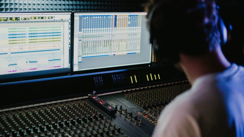 Künstliche Intelligenz in der Musikproduktion: Sound auf Knopfdruck Die Musikproduktion war lange ein Handwerk, das viel Technikverständnis, teure Ausrüstung und vor allem Zeit verlangte. Heute reicht oft ein Laptop, ein Kopfhörer – und zunehmend auch ein KI-Tool, das aus wenigen Vorgaben Beats, Harmonien oder sogar grobe Arrangements ableitet. „Sound auf Knopfdruck“ ist dabei weniger Magie als ein Ergebnis von Machine Learning, Audioanalyse und generativen Modellen, die Muster aus riesigen Datenmengen gelernt haben. Trotzdem ist es ein Fehler, KI als reine Abkürzung zu betrachten. Sie kann den Einstieg erleichtern und Routinearbeiten beschleunigen, aber sie nimmt Ihnen nicht automatisch die kreative Entscheidung ab. Wer die Vorschläge ungefiltert übernimmt, landet schnell bei Ergebnissen, die technisch sauber, aber künstlerisch austauschbar wirken. Wer KI als Werkzeug nutzt, das Optionen liefert, kann dagegen schneller experimentieren und bewusster kuratieren. Was KI heute in der Produktion tatsächlich leistet KI in der Musikproduktion ist kein einzelnes Feature, sondern eine ganze Palette an Anwendungen. Einige Systeme generieren musikalisches Material wie Melodien, Akkordfolgen oder Drum-Patterns. Andere unterstützen beim Sounddesign, etwa indem sie aus einem Preset viele Varianten erstellen oder Klangfarben an eine Referenz annähern. Ein dritter Bereich ist die technische Assistenz: Tools erkennen Timing-Probleme, reduzieren Rauschen, helfen beim De-Esser, schlagen EQ-Korrekturen vor oder erstellen einen ersten Mastering-Entwurf. Wichtig ist die Unterscheidung zwischen „generativ“ und „assistierend“. Generative KI erstellt neues Material auf Basis von Eingaben (Prompts, Genre-Hinweisen, Referenzen). Assistierende KI analysiert vorhandenes Audio und optimiert es. Beides kann beeindruckend wirken – aber es bleibt eine Vorstufe: Der entscheidende Schritt ist die künstlerische Auswahl und die Frage, warum ein Track genau so klingen soll. Songwriting und Arrangement: Mehr Ideen, weniger Blockade Viele Produzierende kennen den Moment, in dem eine Idee da ist, aber die Umsetzung stockt: Die Hook sitzt, doch die Strophe trägt nicht; der Beat funktioniert, aber der Drop wirkt flach. KI kann hier wie ein Ideen-Generator arbeiten. Sie liefert alternative Akkordwege, Variationen eines Motives oder rhythmische Abwandlungen, die man selbst vielleicht nicht sofort ausprobiert hätte. Das ist vor allem am Anfang einer Produktion nützlich, wenn es darum geht, schnell unterschiedliche Richtungen zu testen. Gleichzeitig entsteht eine neue Verantwortung: Wenn KI zehn mögliche Hooks anbietet, muss man umso klarer wissen, welche Stimmung, Energie und Dramaturgie man eigentlich sucht. KI erhöht die Menge an Möglichkeiten – Ihre Aufgabe ist es, daraus einen Track mit Aussage zu formen. Sounddesign und Vocals: Schneller zum „Signature Sound“, aber nicht ohne Regeln Im Sounddesign ist KI besonders stark, weil Audio mathematisch gut beschreibbar ist: Spektren, Transienten und Dynamik liefern eindeutige Signale. Moderne Tools können aus einem simplen Preset zahlreiche Varianten erzeugen oder aus einer Referenzaufnahme ein „ähnliches“ Klangprofil ableiten. Das beschleunigt den Weg zum passenden Bass, Pad oder Lead-Sound und macht Experimentieren günstiger, weil man weniger Zeit in Trial-and-Error investiert. Bei Vocals wird es sensibler. KI kann Timing glätten, Tonhöhen stabilisieren, Atemgeräusche reduzieren oder Harmonien generieren. Gleichzeitig ist Voice-Cloning technisch möglich, was rechtliche und ethische Fragen aufwirft: Wem gehört eine Stimme, und was ist erlaubt? Für Veröffentlichungen gilt: Einwilligungen, Rechteklärung und Transparenz sind essenziell. Selbst im Hobbybereich lohnt sich Vorsicht, weil man schnell in Grauzonen rutscht, die man später nicht mehr sauber auflösen kann. Mixing und Mastering: „Klingt fertig“ ist nicht automatisch „klingt nach Ihnen“ KI-Mixing-Tools sind für viele der größte Produktivitätshebel. Ein Klick – und der Track klingt plötzlich „geordnet“: Pegel wirken stimmiger, der Bass kontrollierter, die Höhen sauberer. In vielen Fällen ist das ein sinnvoller Startpunkt, vor allem für Produzierende, die noch kein sicheres Gehör für Balance, Kompression und Frequenzkonflikte entwickelt haben. Aber hier liegt auch der Fallstrick: KI tendiert zu Durchschnittsentscheidungen. Das kann professionell klingen, aber auch generisch. Ein charaktervoller Mix entsteht häufig gerade durch bewusste Abweichungen – etwa durch mehr Dynamik, ungewöhnliche Räume, ein raueres Vocal oder eine „zu laute“ Textur, die den Track unverwechselbar macht. Wer KI nutzt, sollte sie als Vorschlagsmaschine verstehen, nicht als finale Instanz. In digitalen Ökosystemen kennt man dieses Prinzip: Plattformen kuratieren große Mengen an Optionen und machen sie über Kategorien auffindbar – etwa bei Hitnspin Casino, wo Inhalte vor allem durch Auswahl, Struktur und Filterlogik navigierbar werden. In der Musikproduktion kuratiert KI ebenfalls Optionen (Presets, Varianten, Mix-Vorschläge). Der Unterschied ist: In der Kunst zählt nicht die größte Auswahl, sondern die stärkste Entscheidung. Praktische Leitlinien: KI nutzen, ohne die eigene Handschrift zu verlieren KI kann Ihren Workflow massiv beschleunigen, wenn Sie klare Grenzen setzen. Dann bleibt das Ergebnis „Ihr Track“ – und nicht nur eine generierte Vorlage, die auch hundert andere genauso hätten erstellen können. Wichtig ist, dass Sie vor dem Tool stehen wie ein Produzent mit Ziel, nicht wie ein Nutzer, der „irgendwas“ generieren lässt. Starten Sie mit einer klaren Absicht: Genre ist zu grob; definieren Sie Stimmung, Tempo und Energie (z. B. „dunkel, minimal, treibend“). Nutzen Sie KI zuerst als Skizzen-Tool: Ideen sammeln, dann selbst arrangieren, kürzen, brechen, neu kombinieren. Begrenzen Sie Varianten bewusst: Zu viele Optionen erzeugen Entscheidungsstress; wenige Optionen fördern echte Kuratierung. Definieren Sie Ihr „menschliches Element“: Groove, Vocals, Live-Aufnahmen oder bewusst unperfekte Takes als Signatur. Arbeiten Sie mit Referenzen – aber kopieren Sie nicht: KI kann „ähnlich“ treffen, Identität entsteht durch Distanz zum Vorbild. Prüfen Sie Lizenzen und Rechte vor Release: Besonders bei Samples, Stimm-Tools und vorgefertigten KI-Bausteinen. Nach dieser Liste wird klar: KI ist am stärksten, wenn sie Routine reduziert und Experimente beschleunigt. Schwächer wird sie dort, wo man ihr die künstlerische Verantwortung überlässt und nur noch „abnickt“. Warum „Sound auf Knopfdruck“ die Kreativität eher verschiebt als ersetzt Der wichtigste Perspektivwechsel lautet: KI senkt die Einstiegshürde, aber sie ersetzt nicht musikalisches Urteilsvermögen. Wenn mehr Menschen schneller Musik produzieren können, steigt die Menge an Releases – und damit wird Originalität wichtiger, nicht unwichtiger. Tracks, die nur „korrekt“ klingen, gehen im Strom unter. Tracks, die eine klare Haltung und erkennbare Ästhetik haben, bleiben hängen. Außerdem verändert sich die Rolle von Produzierenden: Sie werden stärker zu Kuratorinnen und Kuratoren, die aus Rohmaterial eine Erzählung bauen. Dieses Prinzip kennt man aus anderen digitalen Bereichen, in denen man Optionen vergleicht und Kriterien abwägt – ähnlich wie bei einem strukturierten Überblick über ein Casino, nur eben angewandt auf Klang, Arrangement und Mix-Entscheidungen. Am Ende zählt nicht, wie schnell etwas entstanden ist, sondern ob es etwas ausdrückt – und ob Sie als Produzentin oder Produzent eine eigene Perspektive hörbar machen. Wenn Sie KI sinnvoll integrieren möchten, beginnen Sie mit einem kleinen Experiment: Lassen Sie sich zwei bis drei Varianten für Intro oder Hook erzeugen, wählen Sie eine Richtung aus und bauen Sie anschließend bewusst „gegen den Durchschnitt“ – mit eigenen Sounds, markanten Pausen oder einer ungewöhnlichen Dynamik. So wird KI zum Turbo, ohne dass Ihre Musik ihre Persönlichkeit verliert.